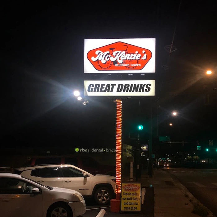 Illuminated sign for Mckenzie's with cars and street lights in the background