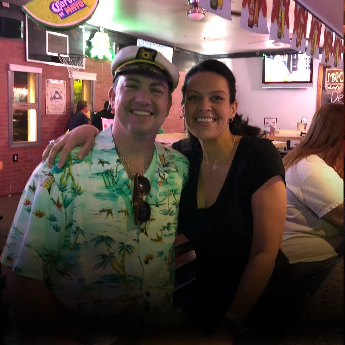 Ryan and Abby posing for a photo in a casual setting with a colorful shirt and sunglasses
