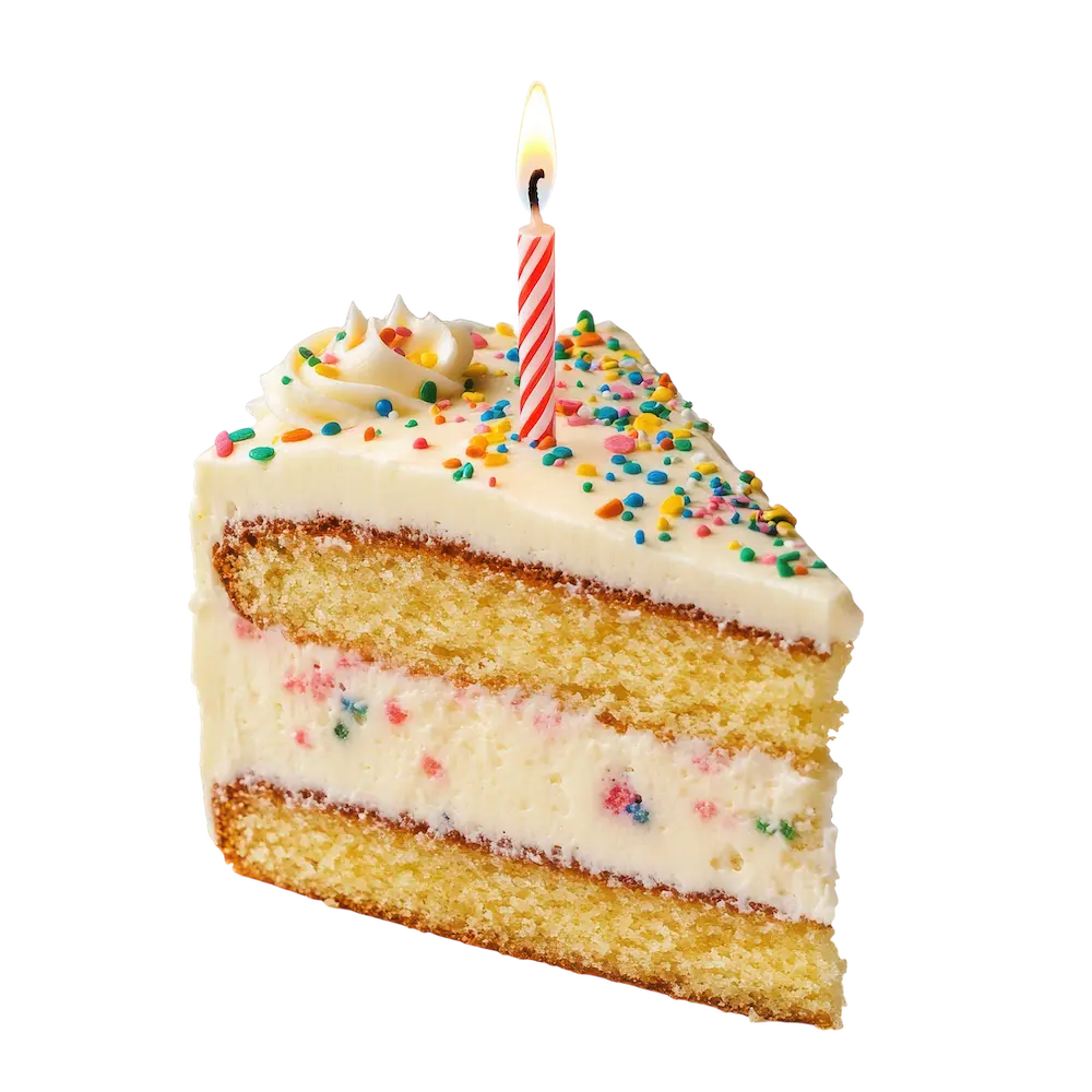 Slice of birthday cake with white frosting, colorful sprinkles, and a lit candle